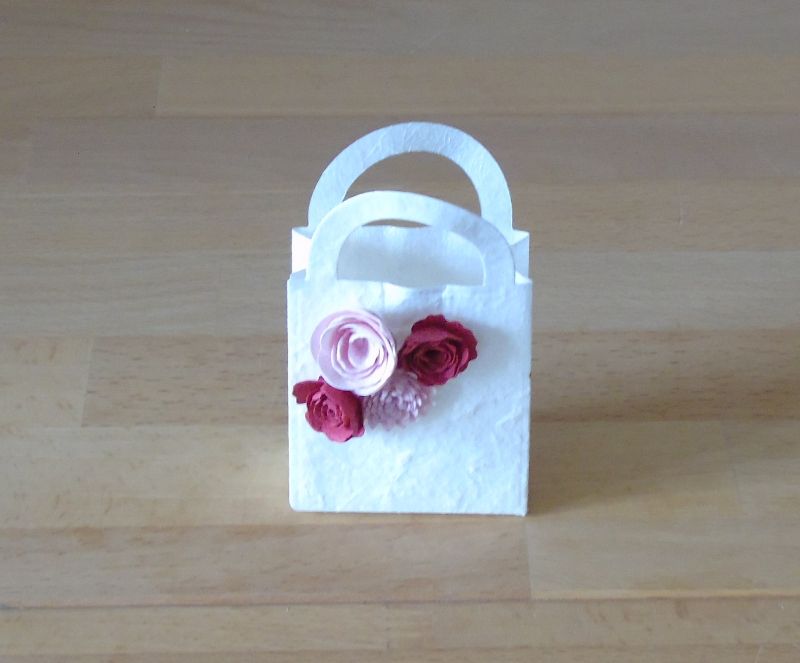  - Geschenkverpackung - kleines Täschchen aus weißem Maulbeerbaumpapier mit vier Miniröschen in Rot und Rosa