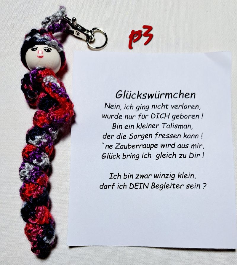  - Glücks-oder Sorgenwürmchen mit Spruch und mit Haken in Geschenktüte lila-weiß-rot-schwarz  Accessoire
